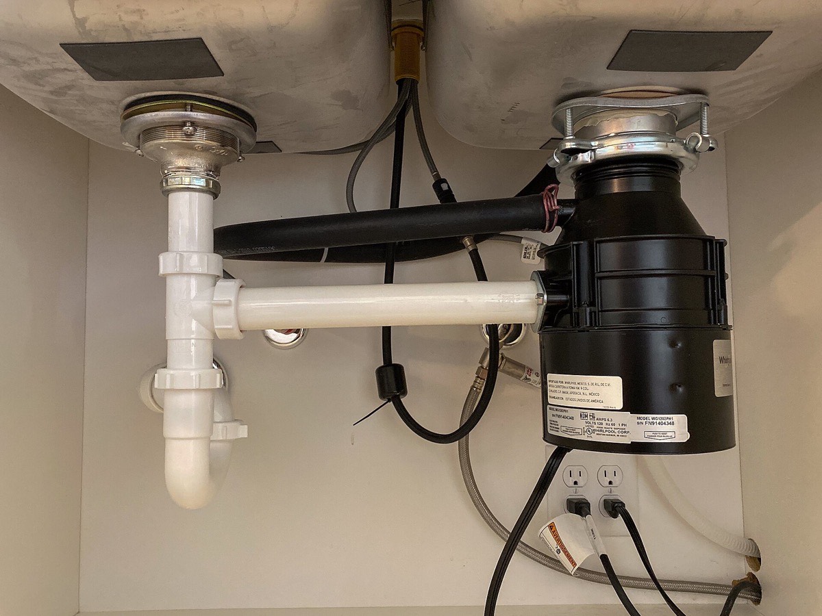 Drain lines and supply hoses under a kitchen sink